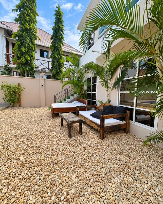 Rustic wooden sofa and cushioned lounger in the hotel's garden