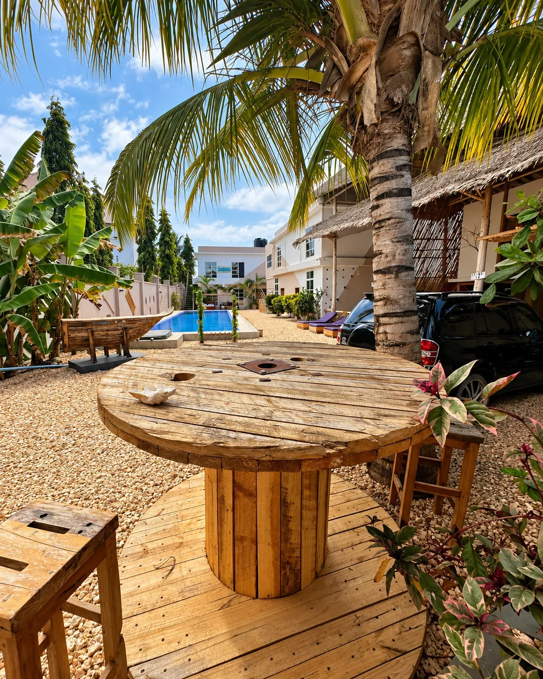 Open-air seating beneath a large palm at VICK Boutique Hotel