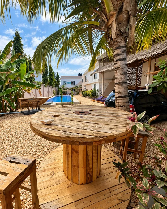 Wooden table beneath palm trees in the VICK garden
