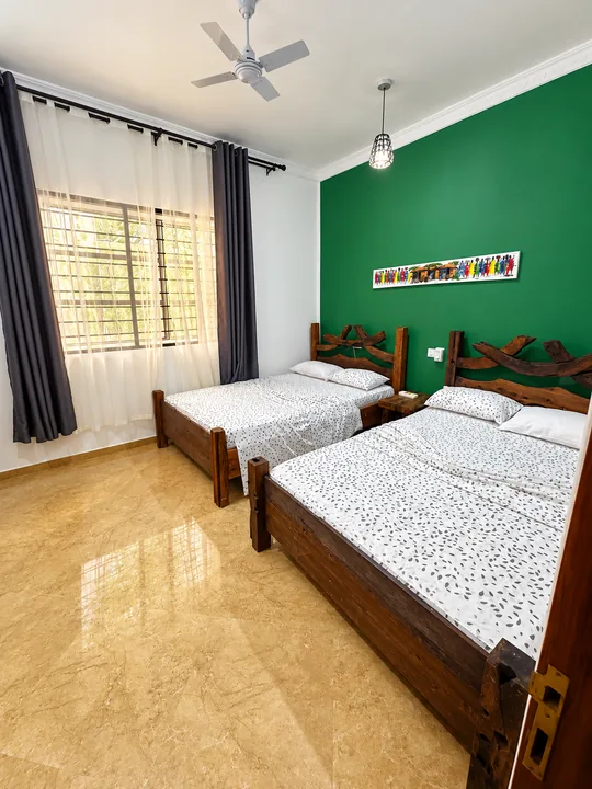 Room 701: two separate full-sized double beds with green accent wall