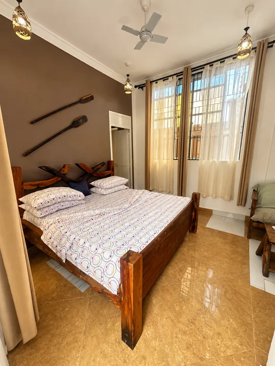 Double Room 702: wooden double bed and warm brown accent wall
