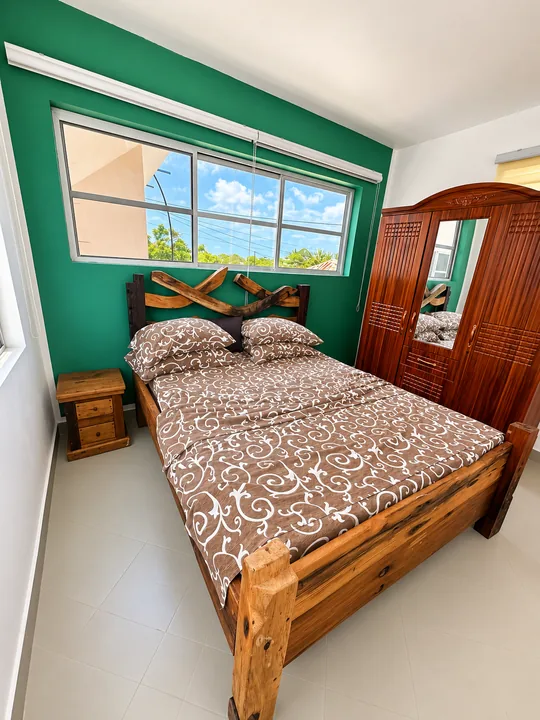 Two-Bedroom Apartment 705: bedroom with green accent wall and wooden double bed
